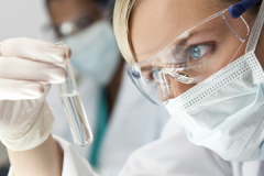 Female Scientific Research Team With Clear Solution In Laboratory